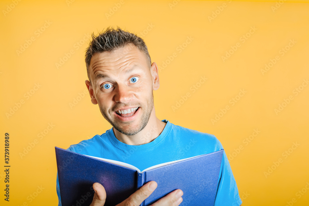 man reads a book against a bright wall man reads a book against a bright wall