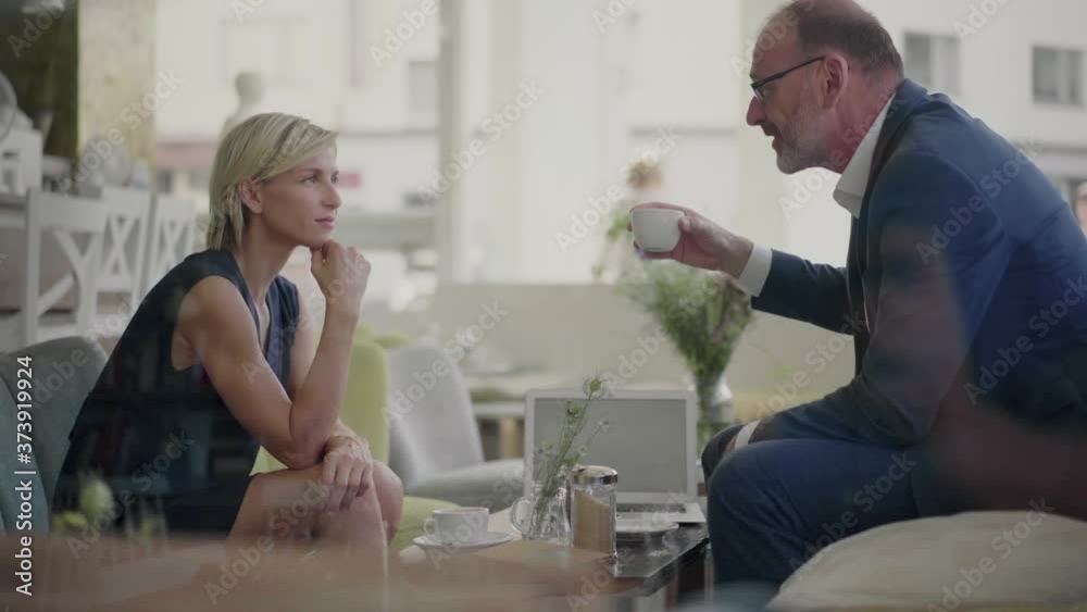 Businessman and woman having a meeting in coffee shop Businessman and woman having a meeting in coffee shop