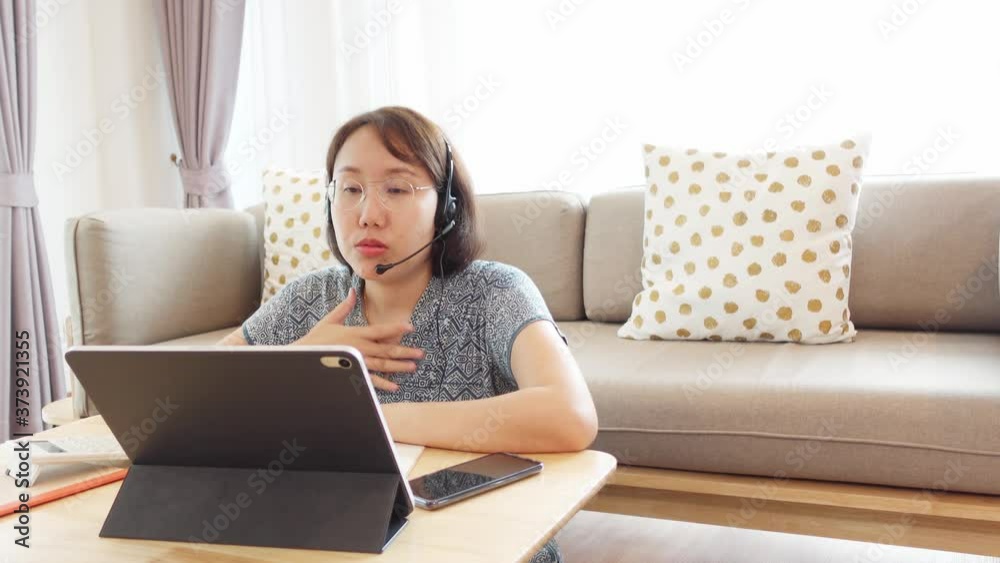 Asian woman aged 30-35 years using tablet, watching lesson online course communicate by conference video call from home, e-learning education concept. 4k Asian woman aged 30-35 years using tablet, watching lesson online course communicate by conference video call from home, e-learning education concept. 4k