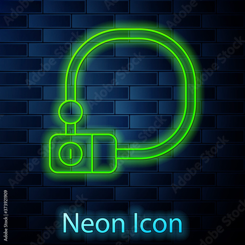 Glowing neon line Bicycle lock U shaped industrial icon isolated on brick wall background. Vector.