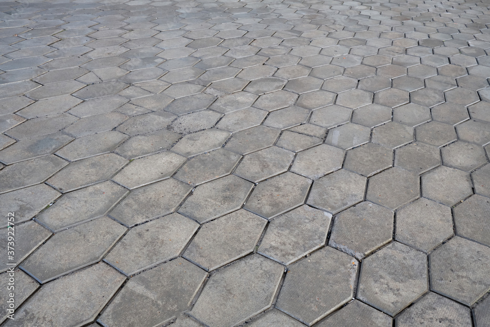 Old pavement of granite texture. Street hexagonal cobblestone sidewalk. Perspective View of Monotone Grunge Gray Brick Stone on The Ground for Street Road. Old pavement of granite texture. Street hexagonal cobblestone sidewalk. Perspective View of Monotone Grunge Gray Brick Stone on The Ground for Street Road.
