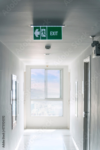 Fototapeta Naklejka Na Ścianę i Meble -  Emergency exit sign and Fire Extinguisher on the corridor in hotel or office building.