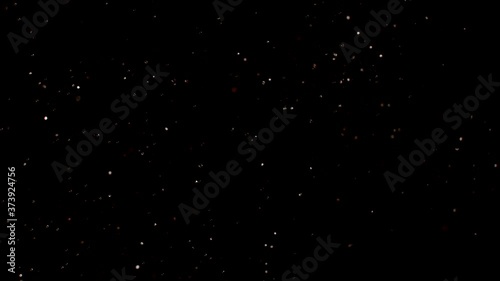 Dust particles sparkling on black background with white light bokeh effect