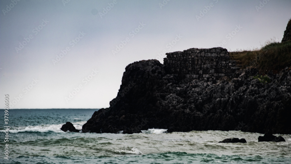 Beautiful Landscape with a black rock cliff with rough sea