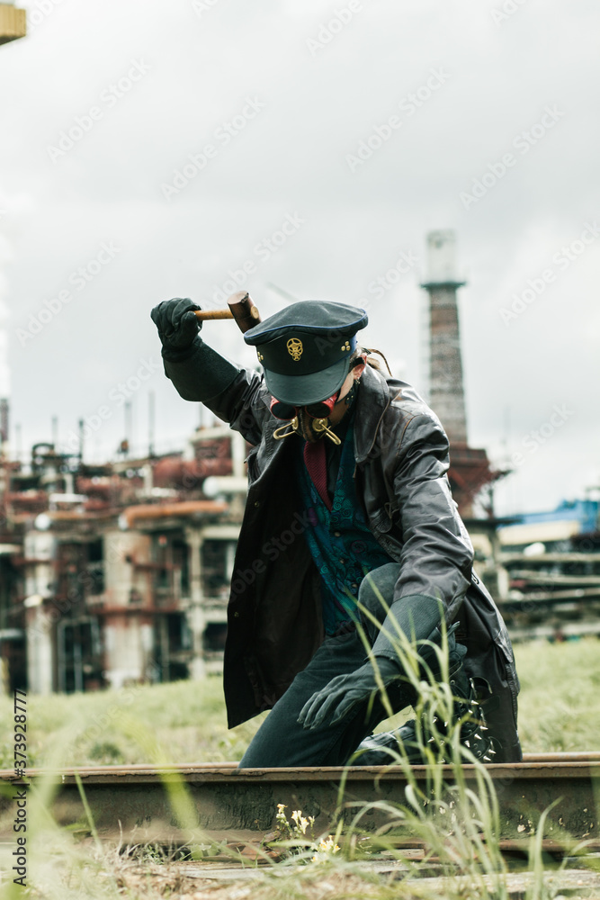 Young man with hammer weared in steampunk style