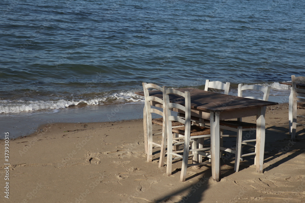 Free beach chairs and tables in beach restaurant in Greece