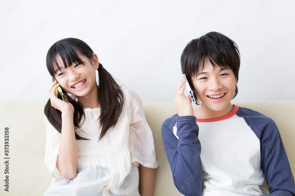 スマホで電話する姉弟