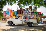 Vendedor ambulante latino mexicano vehículo comercio informal negocio emprendedor comerciante portátil colorido escobas utensilios tianguis mercado