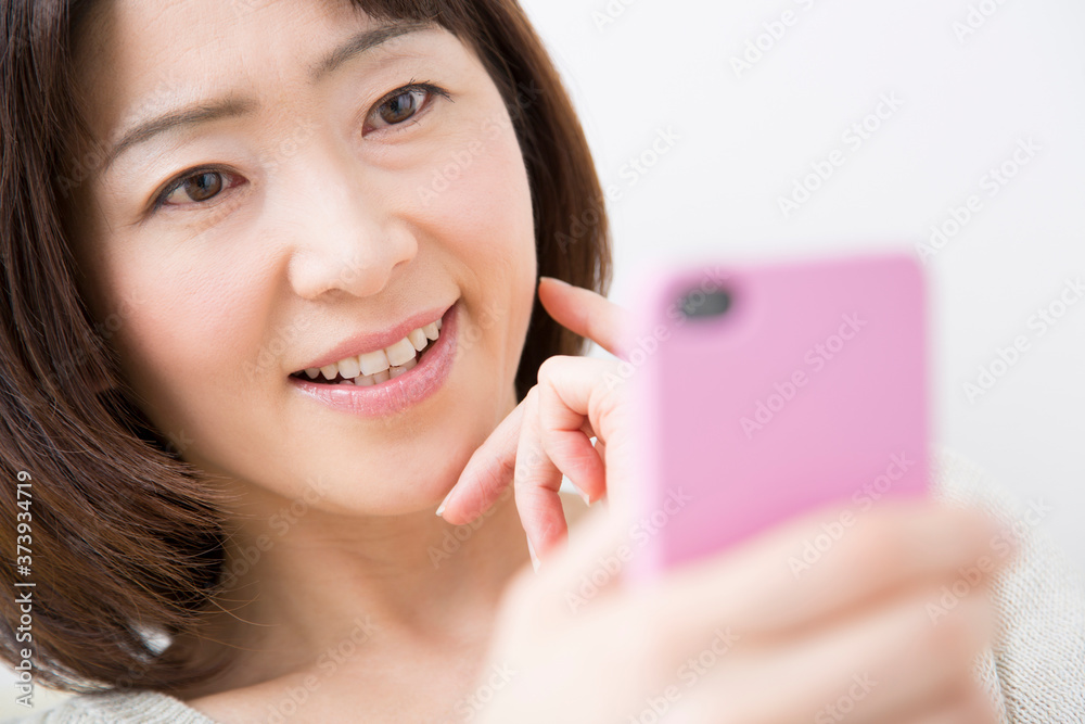 スマホを見る中年女性 スマホを見る中年女性