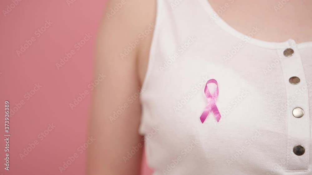 custom made wallpaper toronto digitalSymbol of breast cancer awareness month, pink october badge on the white shirt of unrecognizable woman. Removing the ribbon from the t-shirt High quality 4k footage