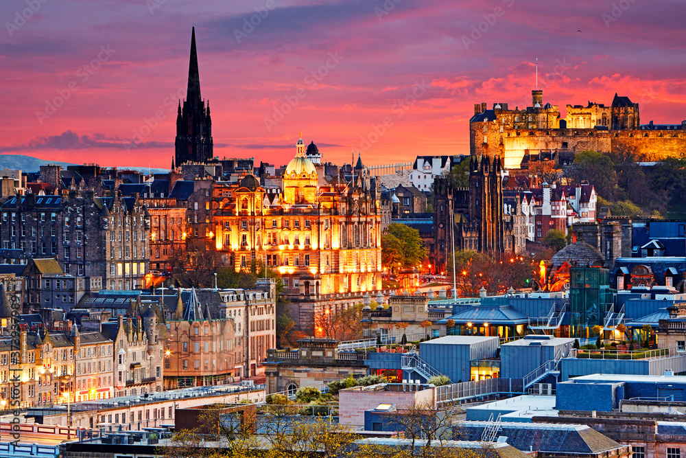 Obraz premium Aerial view of the skyline of Edinburgh with Edinburgh Castle illuminated at sunset