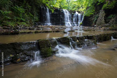 Hidden waterfall in a deep gorge with trickling white water. Forest of Bowland, Ribble Valley, Lancashire