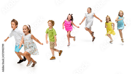 Happy children, little and emotional caucasian kids jumping and running isolated on white background. Looks happy, cheerful, sincere. Copyspace for ad. Childhood, education, happiness concept. © master1305