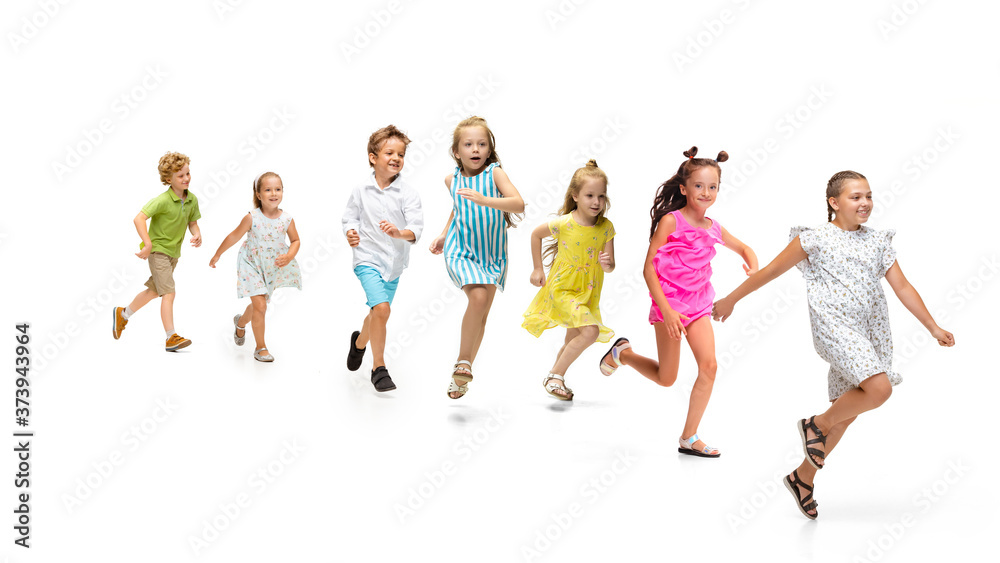 Obraz premium Happy children, little and emotional caucasian kids jumping and running isolated on white background. Looks happy, cheerful, sincere. Copyspace for ad. Childhood, education, happiness concept.