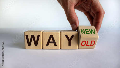 Hand turns a cube and changes the words 'way old' to 'way new'. Business concept. Beautiful white background, copy space.