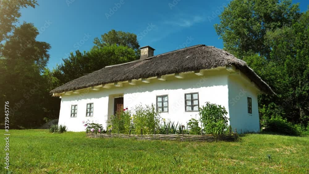 Old white Ukrainian hut with thatch roof in the settlement Old white Ukrainian hut with thatch roof in the settlement