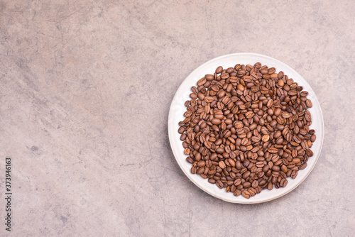Roasted coffee beans on a textured background, empty copy space