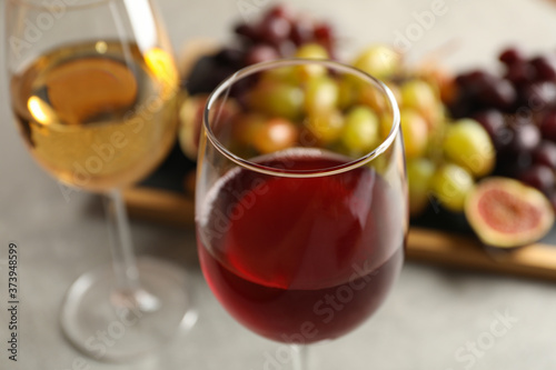 Composition with glasses of wine and grape on gray table