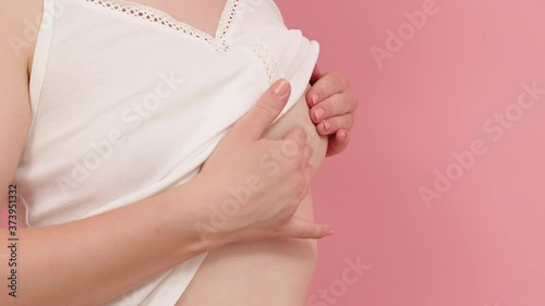 Wallpaper Mural Woman examining her breast. Breast cancer awareness concept. Isolated on pink background. High quality 4k footage Torontodigital.ca