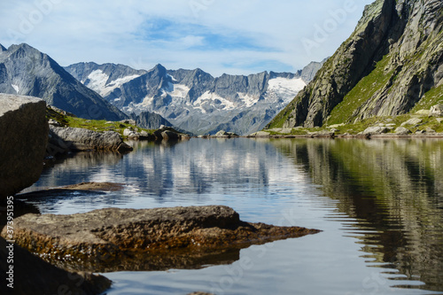 Bergsee mit Spiegelung eines Gebirges im Hintergrund in Tirol Österreich
