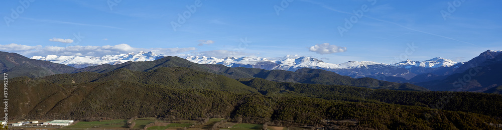 panoramic view of the pyrenees in winter with snow and a blue sky