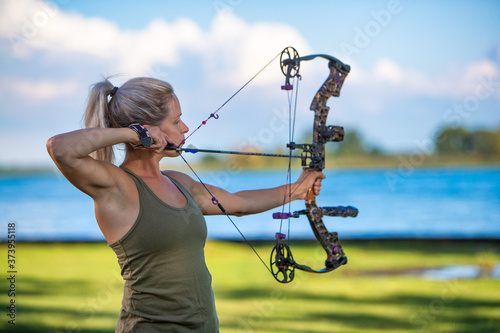 Foto young woman aiming a compound bow