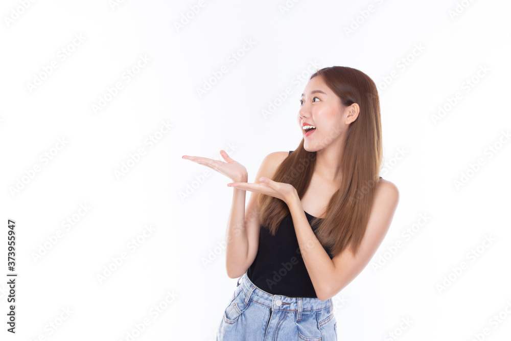 Fashion of a beautiful young asian woman in a pretty black vest and blue jeans feeling smile and happy. Girl pointing up with index finger to copy space isolated on white background. Fashion of a beautiful young asian woman in a pretty black vest and blue jeans feeling smile and happy. Girl pointing up with index finger to copy space isolated on white background.