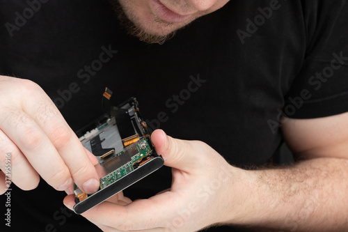 The master collects a smartphone from the parts in the phone repair service