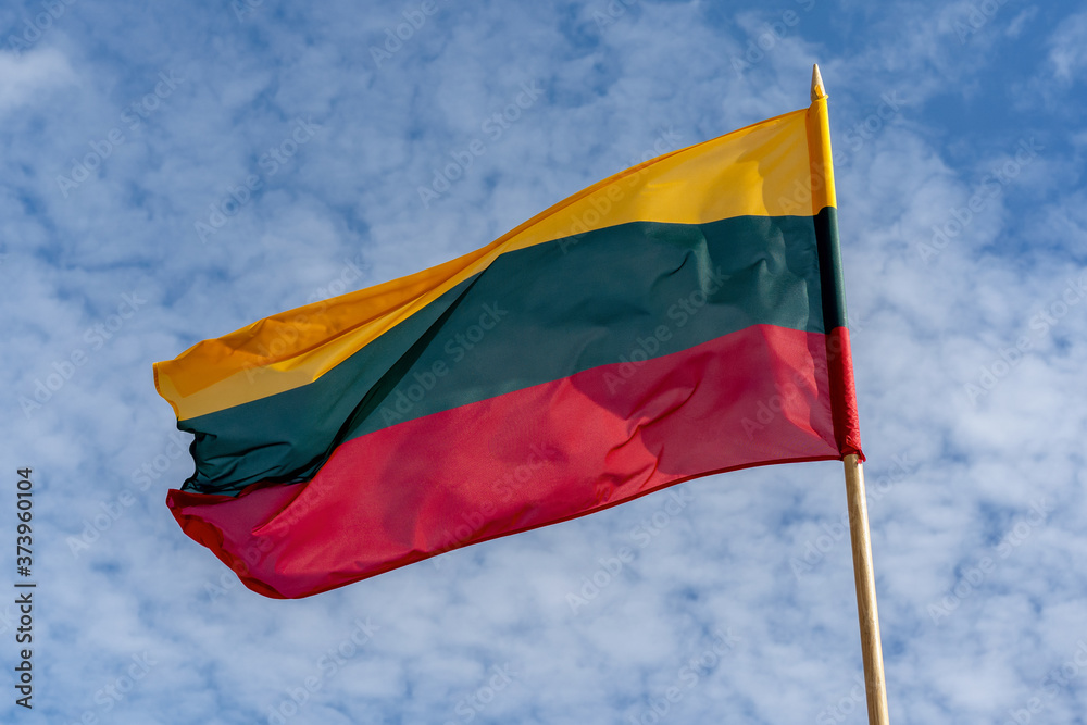 Lithuanian national tricolor flag waving in a beautiful cloudy sky. Lithuanian national tricolor flag waving in a beautiful cloudy sky.