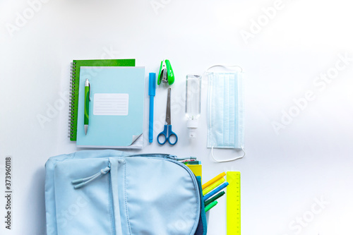 Back to school after coronavirus pandemic. Backpack, face mask on a white background. 