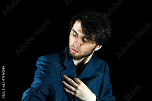 A young man looking the other way while his hand is on the suit