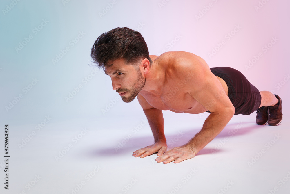 Full length portrait young fitness sporty strong guy bare-chested muscular sportsman isolated on white background studio portrait. Workout sport motivation lifestyle concept. Doing push-ups exercises. Full length portrait young fitness sporty strong guy bare-chested muscular sportsman isolated on white background studio portrait. Workout sport motivation lifestyle concept. Doing push-ups exercises.