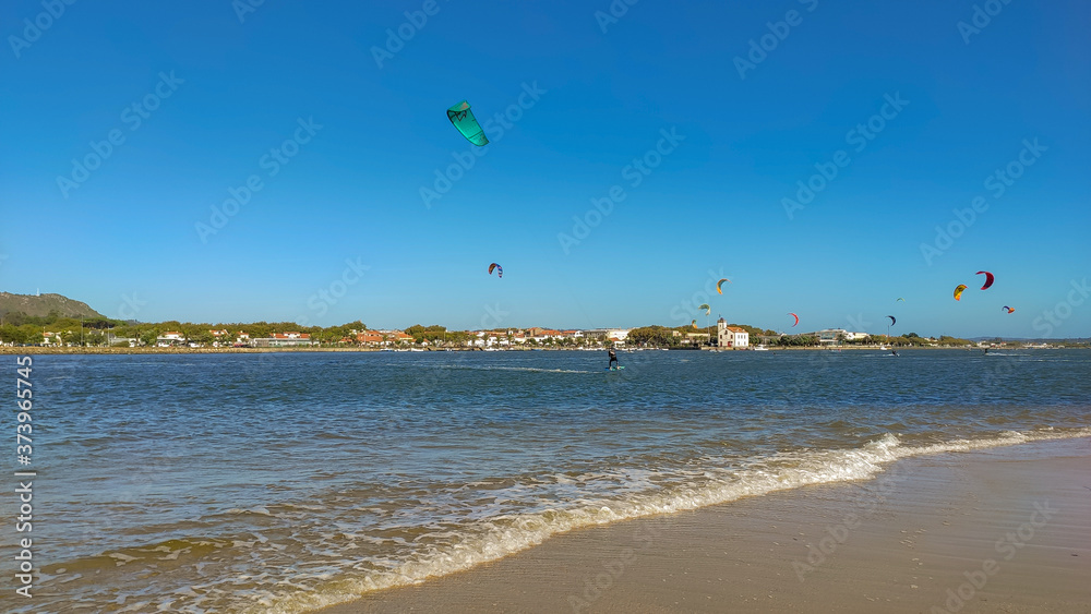 People practicing kitesurf. Kitesurfers on the mouth of the Cavado River in Esposende, Portugal. Esposende it's renowned by kite-surfers as one of the best places to kitesurf.