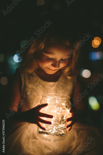 Young toddler girl holding magic fairy lights