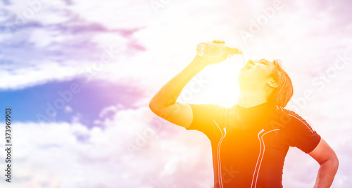 Bilde på lerret asian man in black sportswear stand and drinking clean or pure water after exerc