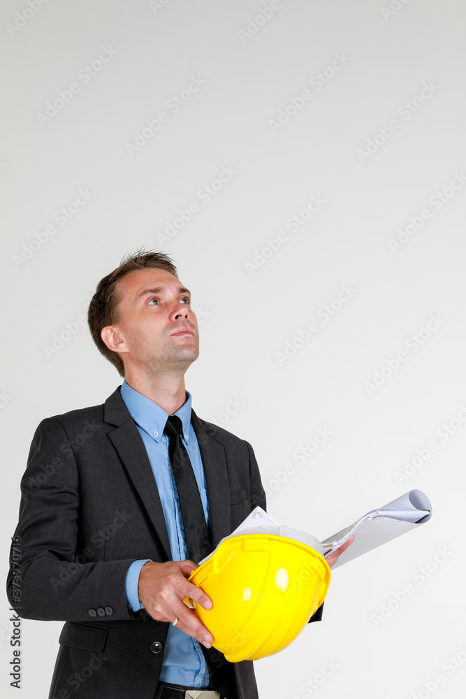 portrait of a caucasian architectual Engineer wearing hardhat looking at the construction layout drawing on white background copy space portrait of a caucasian architectual Engineer wearing hardhat looking at the construction layout drawing on white background copy space