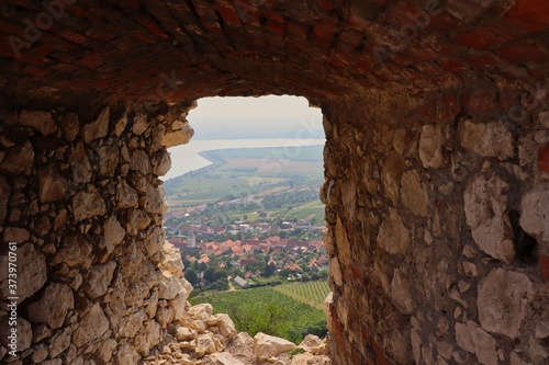 View of Village Pavlov from Window of Ruins of Devicky Castle in Palava Protected Landscape Area. Rock Window with the View of Rural Village in South Moravia  Czech Republic.