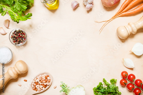 Top view of a saucepan and a variety of fresh raw vegetable ingredients for making vegetable soup with copy space.