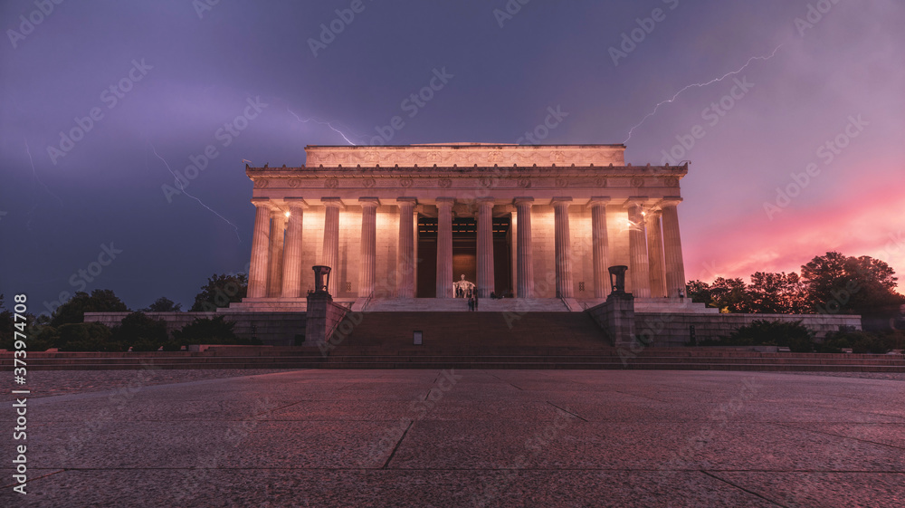Obraz premium Lightning strikes behind the Lincoln Memorial at sunset in Washington, D.C.