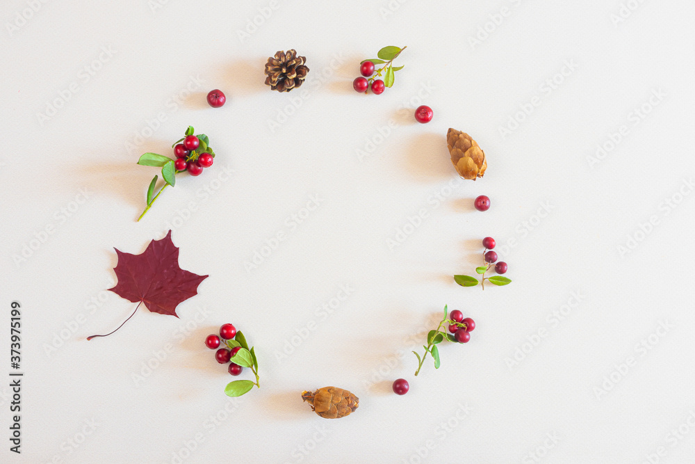 Autumn flat lay: red and yellow leaves, red berries, cones on a pastel neutral background. Top view, copy space.