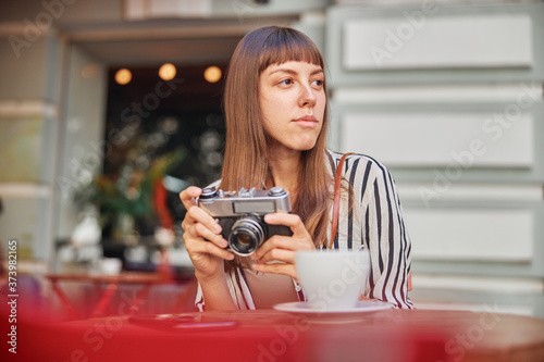 Young woman with camera looking away