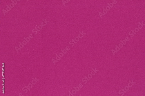 The texture of the fuchsia knit fabric. Beautiful background of bright pink natural cotton fabric.