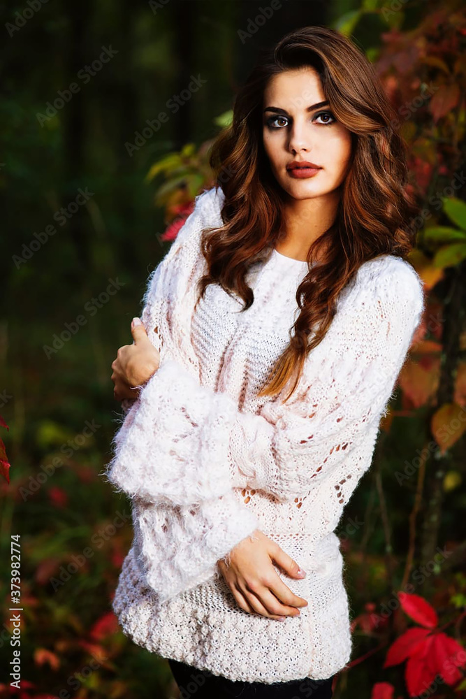 Woman in knitted sweater posing in autumn forest
Woman in knitted sweater posing in autumn forest