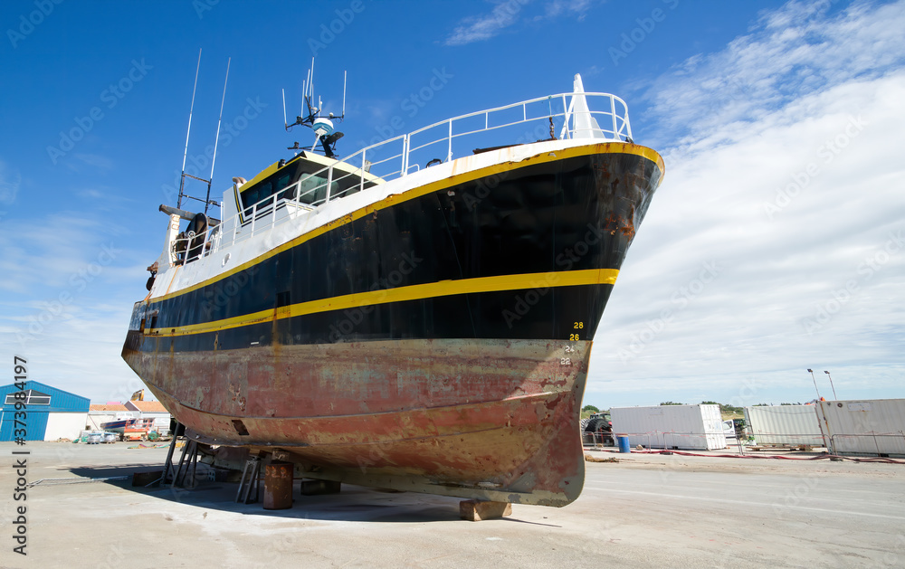 Fishing boat in dry dock, wide angle photo with blue sky in Oleron Island, France Fishing boat in dry dock, wide angle photo with blue sky in Oleron Island, France