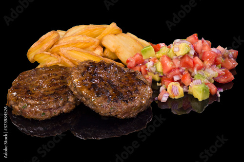 Delicious beef steak garnished with boiled potatoes and fresh salad, with reflection