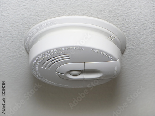Close up of a ceiling mount white smoke detector used in homes.
