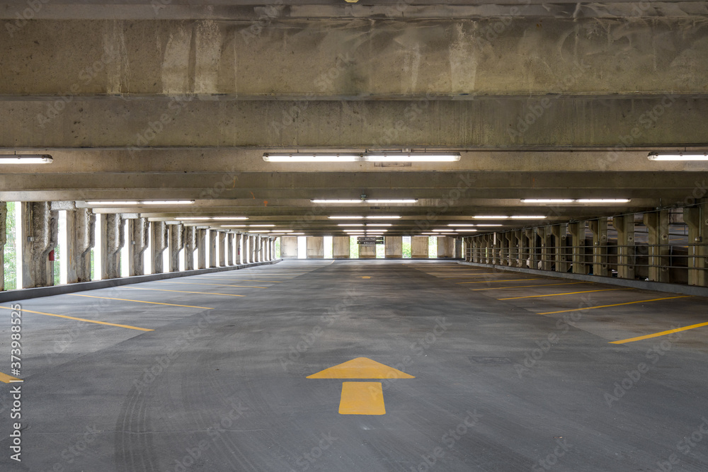Empty parking garage with yellow lines for parking spaces and yellow