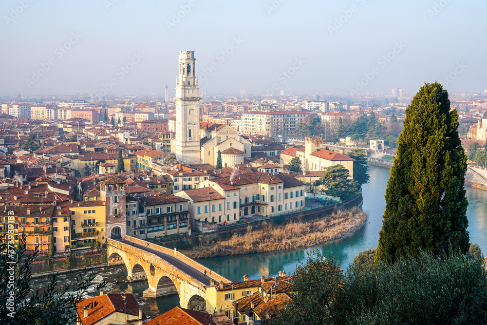 Beautiful view of the bell tower of cattedrale di Verona and Ponte Pietra on the banks of the Adige River. Verona, Italy