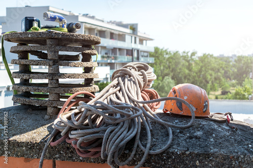 Industrial alpinism and rope access equipment and protective gear on top of the building with other tools around