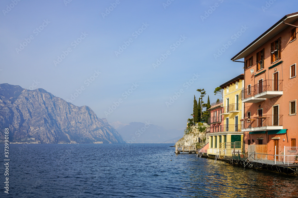 Colorful houses in Malcesine at Garda Lake bank with mountains in background